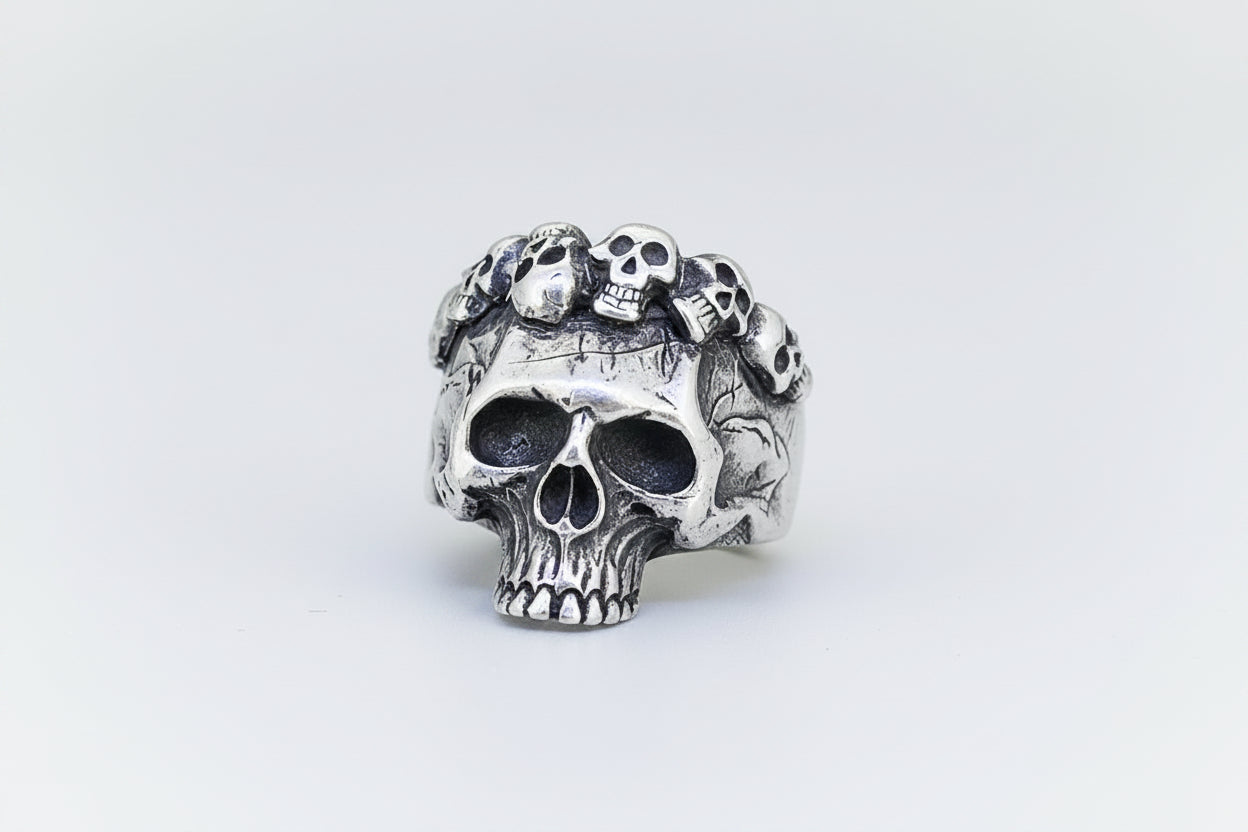 Silver skull ring with small skulls on a light background