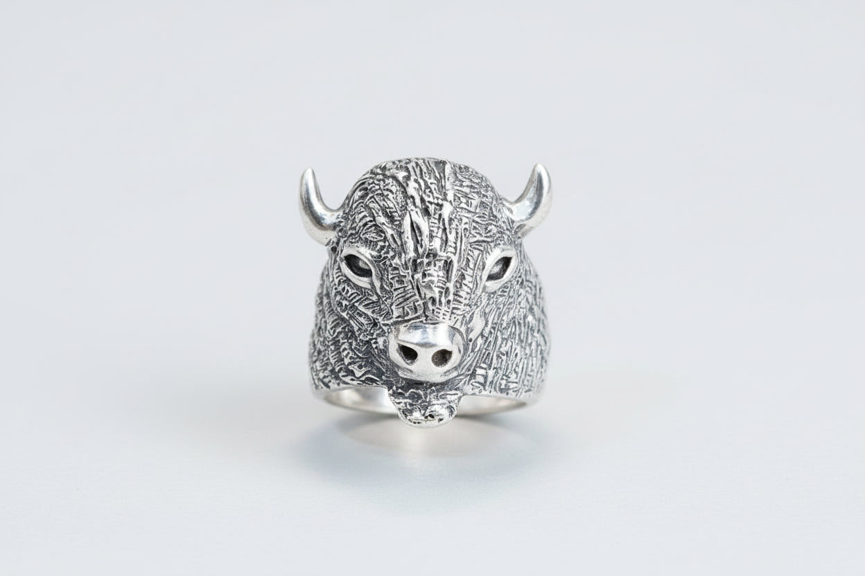 Silver bull head ring on a light gray background
