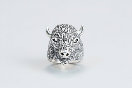 Silver bull head ring on a light gray background